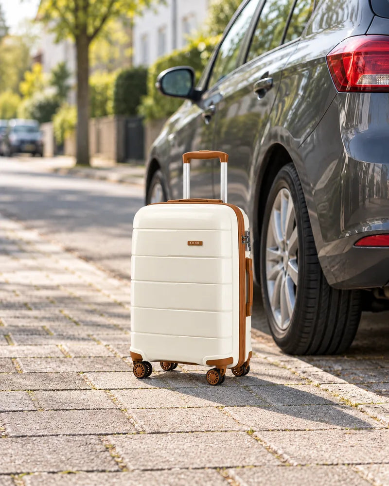 Cream Kono cabin suitcase with brown trim beside a parked hatchback