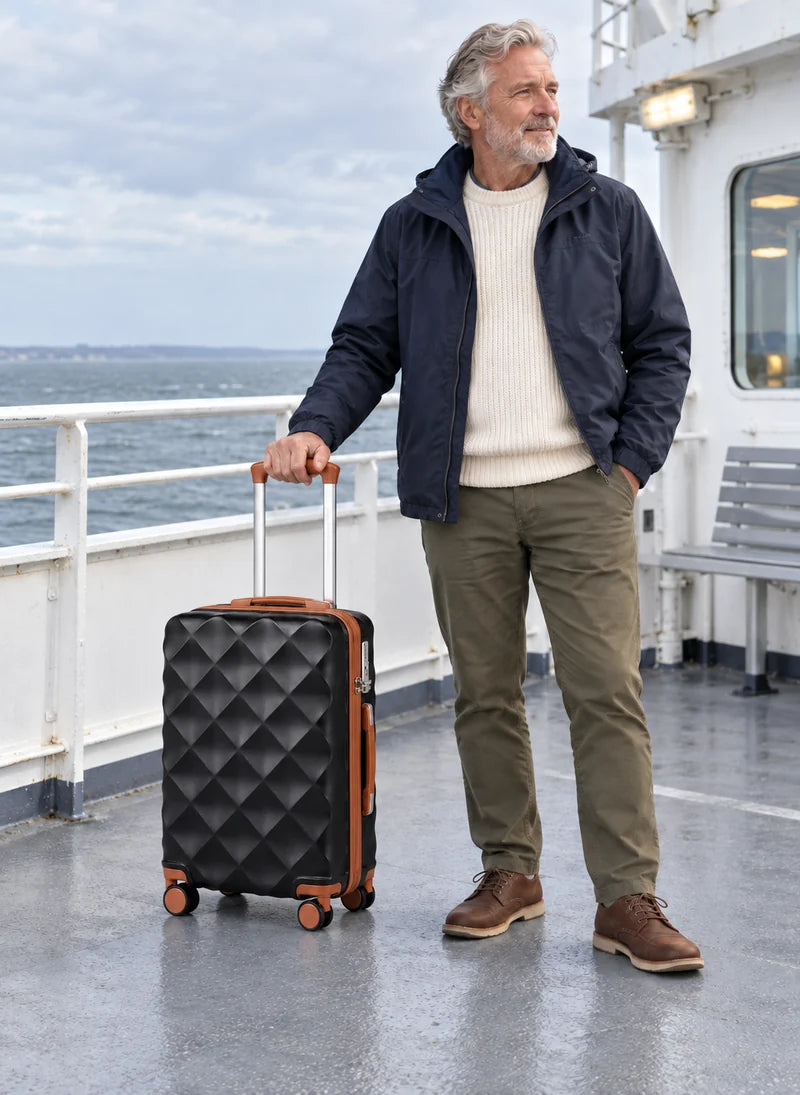 Man holding a black and brown diamond-patterned suitcase on a ferry deck.