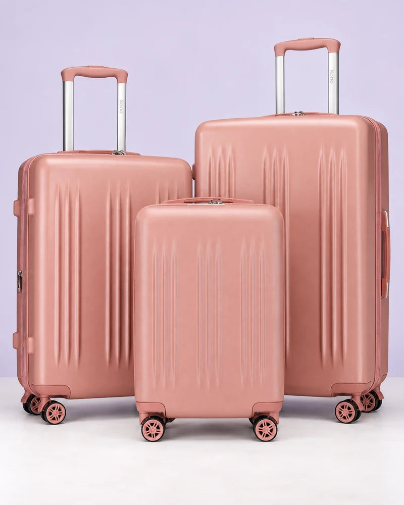 Three rose-pink rolling suitcases against a pale lavender background.